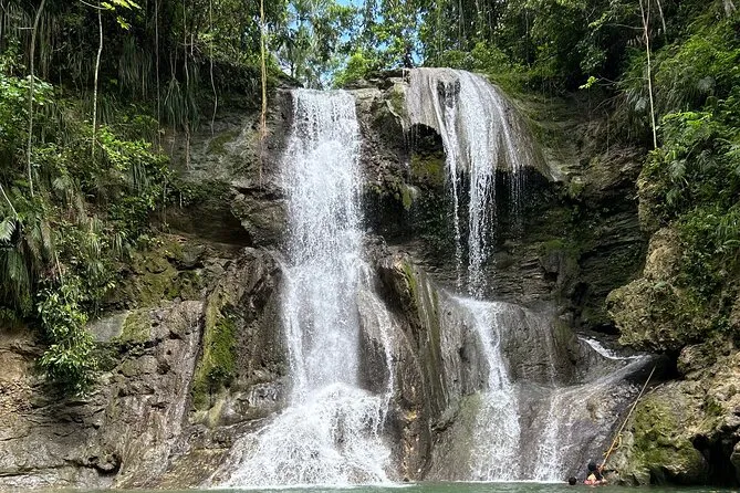 Hiker swimming in the natural waterfall pool at Gozalandia in San Sebastián Puerto Rico